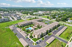 Olathe apartment for rent - A large apartment complex with a pool in the middle of the courtyard.