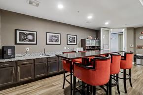 Olathe apartment for rent - A kitchen with a table and chairs in the foreground and a fridge in the background.