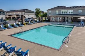 Springdale townhouse for rent - A large swimming pool surrounded by blue lounge chairs.