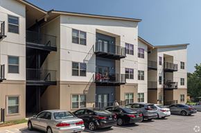 Fayetteville apartment for rent - A row of apartment buildings with cars parked in front.