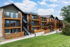 Kansas City apartment for rent - Apartment complex with wooden exteriors and black railings.