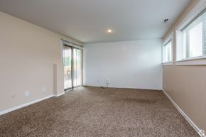 Kansas City apartment for rent - A spacious room with carpeted floor and sliding glass doors.