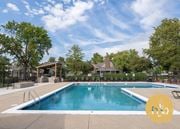 Overland Park townhouse for rent - A large outdoor swimming pool surrounded by trees and a covered area.