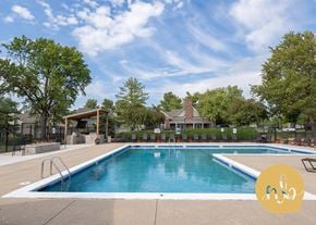 Overland Park townhouse for rent - A large outdoor swimming pool surrounded by trees and a covered area.