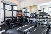Overland Park townhouse for rent - A gym with treadmills, dumbbells, and a sign that says "HIT WORKOUT RESULTS & REVIEWS".