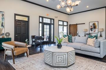 Overland Park townhouse for rent - A living room with a grey sofa, a wooden coffee table, and a chandelier.
