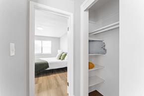 Kansas City apartment for rent - A white bedroom with a bed and a small closet.