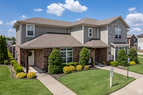 Springdale townhouse for rent - A house with a brown roof and a white sign in front.