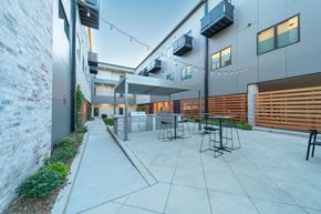 Bentonville apartment for rent - A Patio Area With Table and Chairs at G at Market Apartments, Bentonville, AR