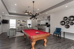 Springdale apartment for rent - A pool table is in the middle of a room with a ceiling fan and a chair.