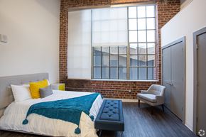 Leavenworth apartment for rent - a bedroom with a large bed and a brick wall