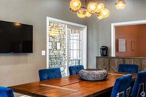 Lenexa apartment for rent - A dining room with a wooden table and blue chairs.