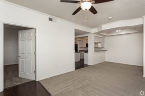 Springdale apartment for rent - A spacious living room with a ceiling fan and carpeted floor.