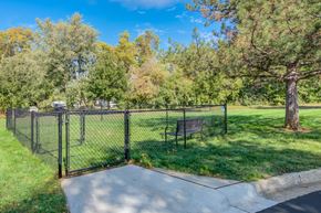 Liberty apartment for rent - A black fence surrounds a park bench in the middle of a grassy area.