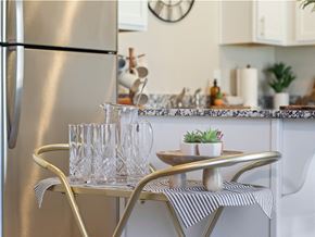 Springdale townhouse for rent - a small kitchen with a table and chairs and a refrigerator at Hillcrest Village, Arkansas
