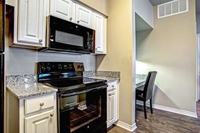 Centerton apartment for rent - full size black kitchen range and nearby built-in desk with chair and granite coutnertop