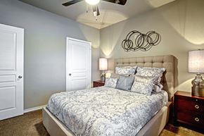 Centerton apartment for rent - model bedroom with ceiling fan and carpet and queen size bed and walk-in closet