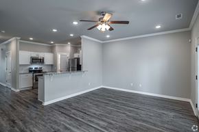 Rogers townhouse for rent - A spacious kitchen and living room with a ceiling fan and lighting.