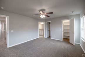 Rogers townhouse for rent - A spacious room with a ceiling fan and carpeted floor.