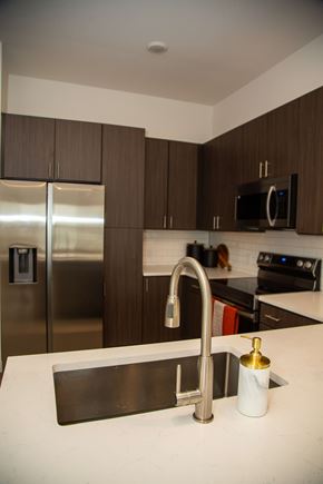 Castle Rock apartment for rent - A kitchen with a stainless steel refrigerator and a black microwave above the stove.