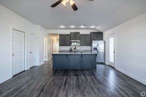 Springdale triplex for rent - A kitchen with a dark wood floor and white walls.