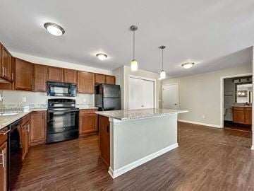 Des Moines apartment for rent - A kitchen with wooden cabinets and a black oven.