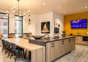 Castle Rock apartment for rent - A modern kitchen with a long wooden island and a dining table with chairs.