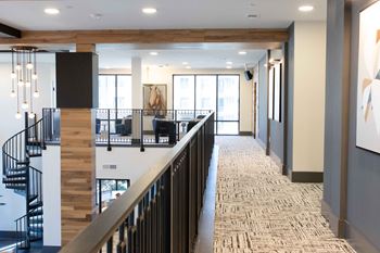 A hallway with a staircase and a carpeted floor.