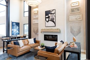 A living room with a fireplace and a painting above it.