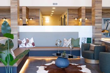A modern living room with a blue couch and a cowhide rug.