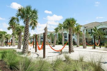 A hammock area in front of a row of houses