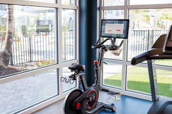 A home gym with a bike in front of a window