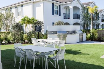 A table and chairs on a lawn in front of a house