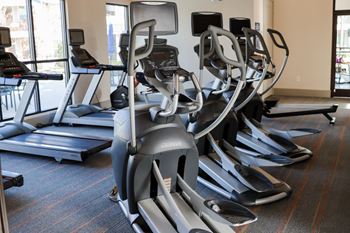 A row of exercise machines in a gym
