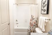 Acworth apartment for rent - A white bathroom with a floral shower curtain.