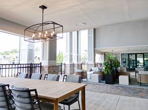 Oakwood apartment for rent - A modern dining area with a long wooden table and chairs. at The Crest at Oakwood Apartments, Oakwood , GA, 30566