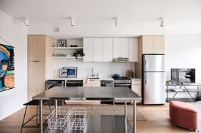 St. Paul apartment for rent - a kitchen with white cabinets and stainless steel appliances and a table and chairs