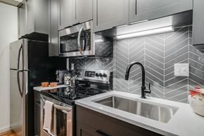 St. Paul apartment for rent - A modern kitchen with a black stove top oven and a black refrigerator.