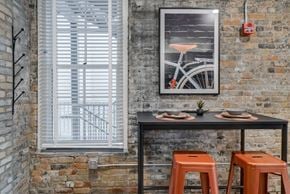 St. Paul apartment for rent - A dining area with a table, two stools and a picture of a bicycle on the wall.