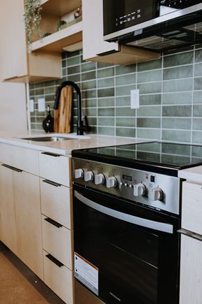 Duluth apartment for rent - a black oven in a kitchen with white cabinets