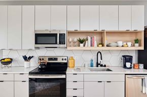 St Paul apartment for rent - a kitchen with white cabinets and a stove and a microwave