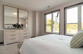 Wayzata apartment for rent - the master bedroom has large windows and a large white bed