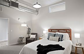 St. Paul apartment for rent - A bedroom with a large bed and a chair.