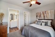 Littleton apartment for rent - A bedroom with a bed, dresser, mirror and a ceiling fan.