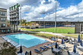 Lawrenceville apartment for rent - an aerial view of a swimming pool with a baseball field in the background