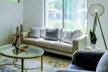 Phoenix apartment for rent - A living room with a white couch and a glass table.
