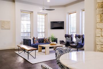 Austin apartment for rent - A living room with a blue couch and a television on the wall.