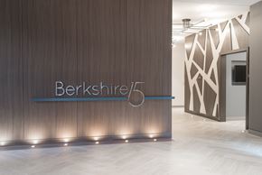 Washington apartment for rent - A modern office lobby with a wooden wall and a sign that reads "Berkshire.".