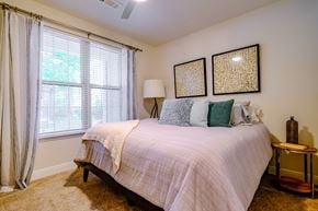 Durham apartment for rent - A bedroom with a bed, a nightstand, and a window with curtains.