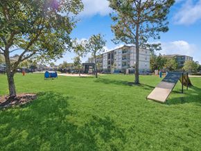 Conroe apartment for rent - A playground with a slide and a green lawn.
